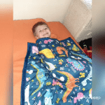 Boy with hearing loss under a weighted blanket