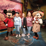 Girl with static encephalopathy enjoys meeting Mickey and Minnie Mouse at Disney World.